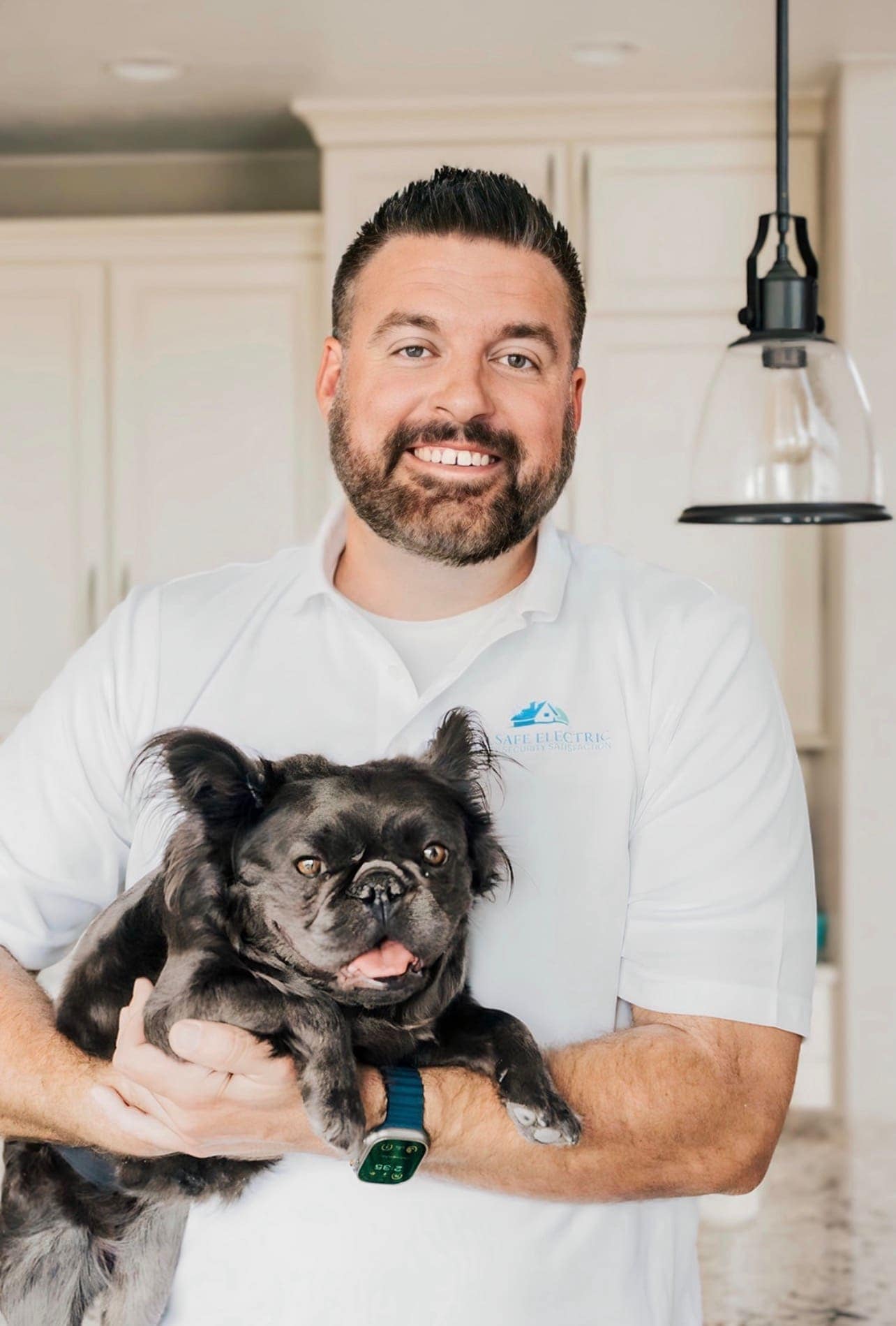 Jud Cushing of Allsafe Electric holding a customer's dog