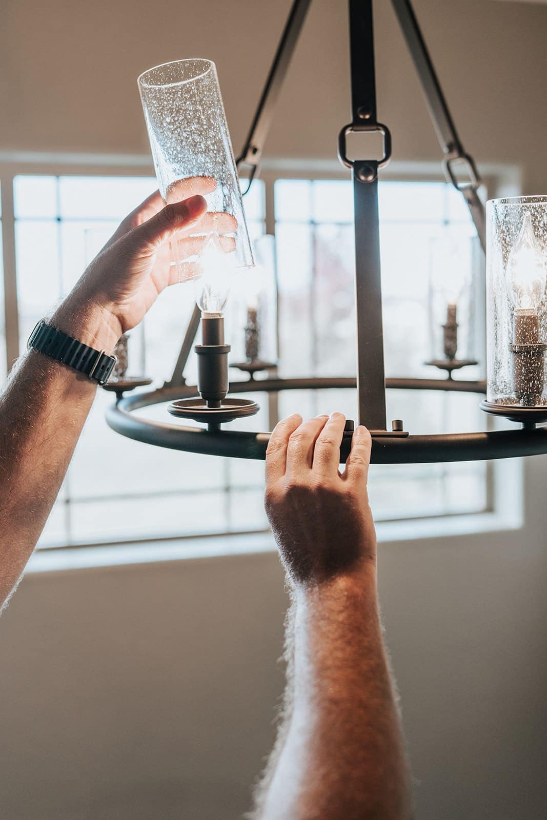 Fitting a glass shade onto a newly hung chandelier