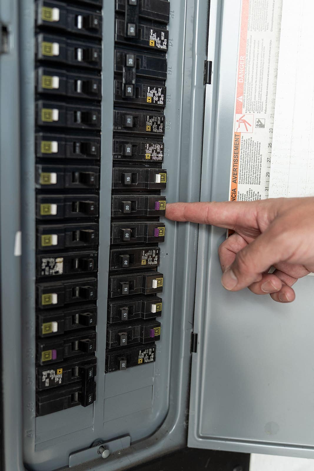 An Allsafe Electric electrician pointing out a breaker during a home visit